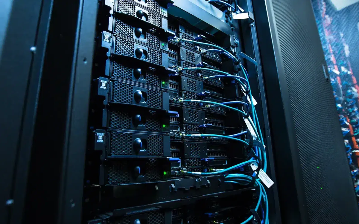 Serveurs montés en rack avec câbles interconnectés dans un centre de données, affichant des voyants d'état actifs et une configuration professionnelle, garantissant des performances optimales pour vos besoins d'hébergement web.