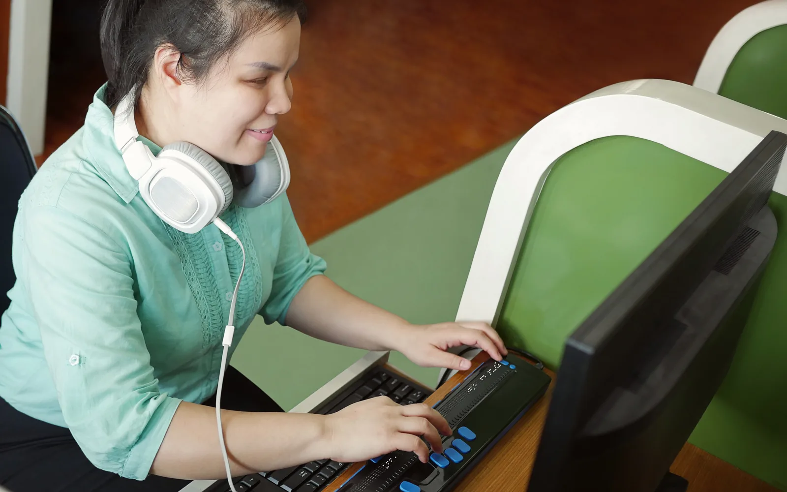 Personne malvoyante utilisant un afficheur braille, illustration de l'accessibilité des boutiques en ligne