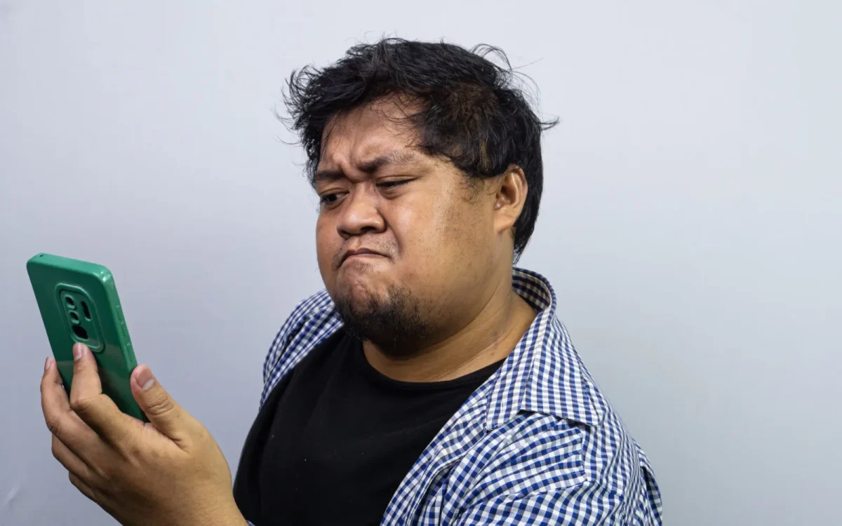 Personne surprise devant son smartphone qui affiche un site inconnu au lieu du site WordPress attendu