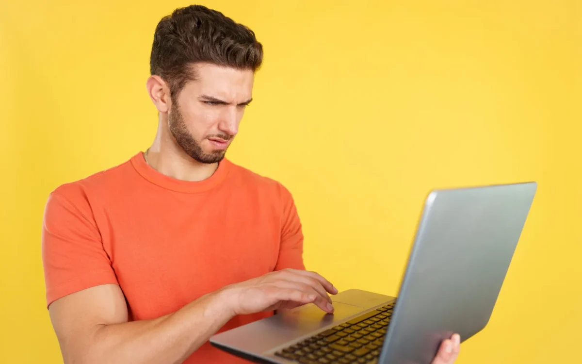 Homme perplexe devant son ordinateur portable affichant une erreur de redirections en boucle sur un site WordPress