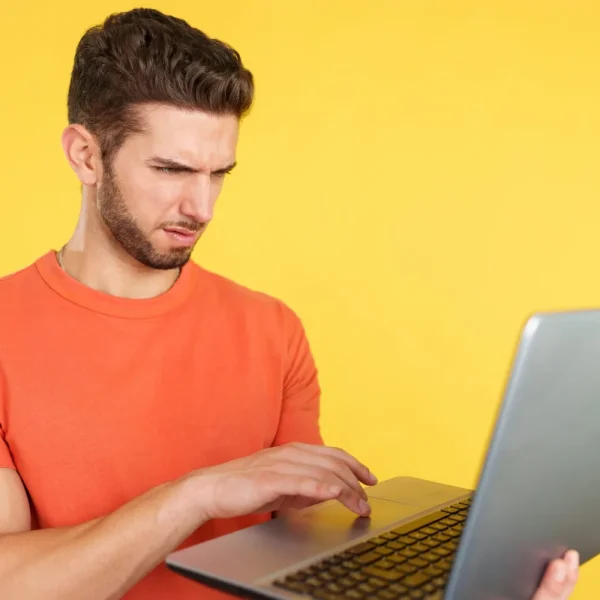 Homme perplexe devant son ordinateur portable affichant une erreur de redirections en boucle sur un site WordPress