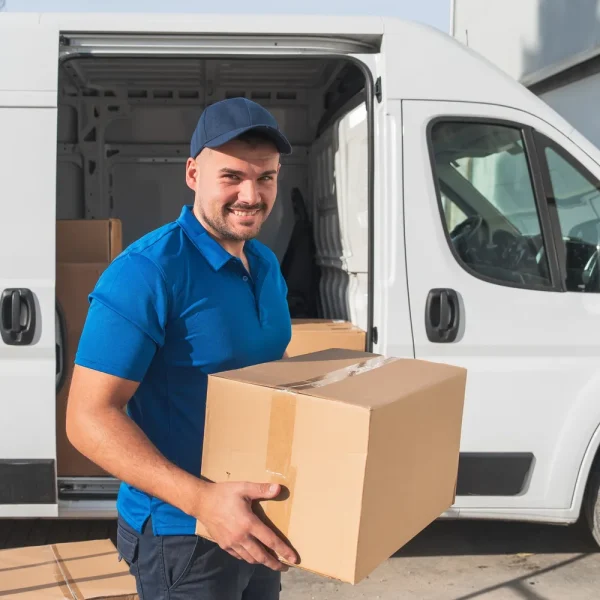 Livreur souriant qui porte un carton devant son fourgon blanc, pour illustrer une boutique WooCommerce qui ne propose plus aucune méthode de livraison